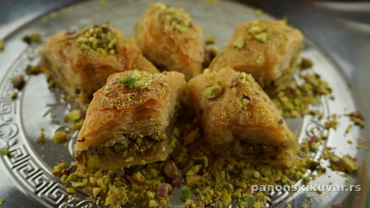 presecena baklava sa zlatnom korom i zelenim mlevenim pistaćima na vrhu