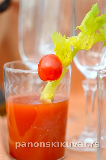 visoka čaša bloody mary sa ledom, grančicom celera i sveže mlevenim biberom