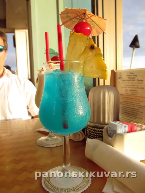 plavi Blue Hawaiian u visokoj čaši sa ledom i ananasom