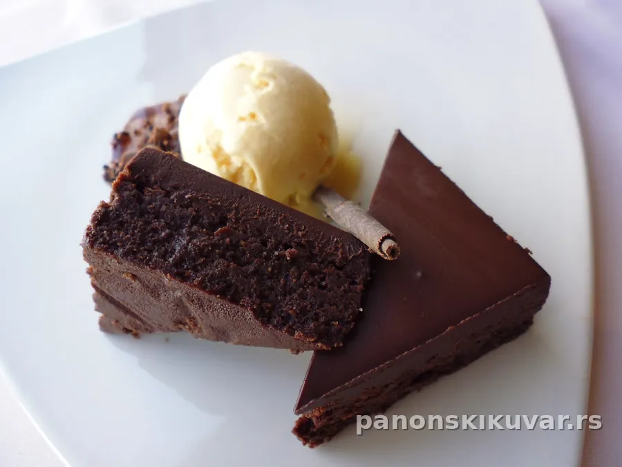 sočna čokoladna torta sa tamnom sjajnom glazurom i presečenim parčetom