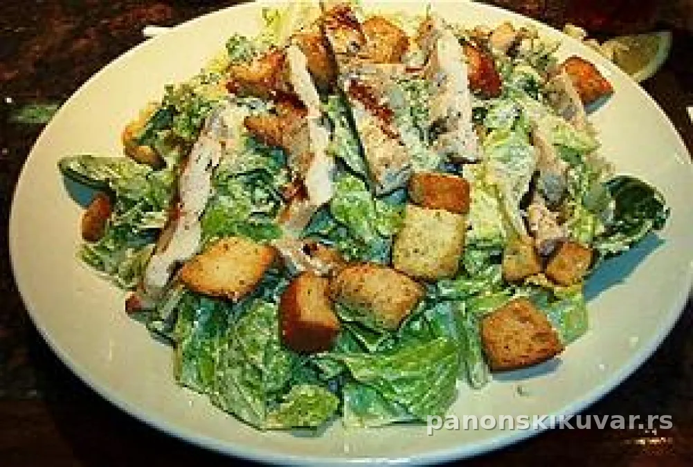 cezar salata sa piletinom, slaninom i dvopekom, posuta parmezanom, sa kriškama limuna