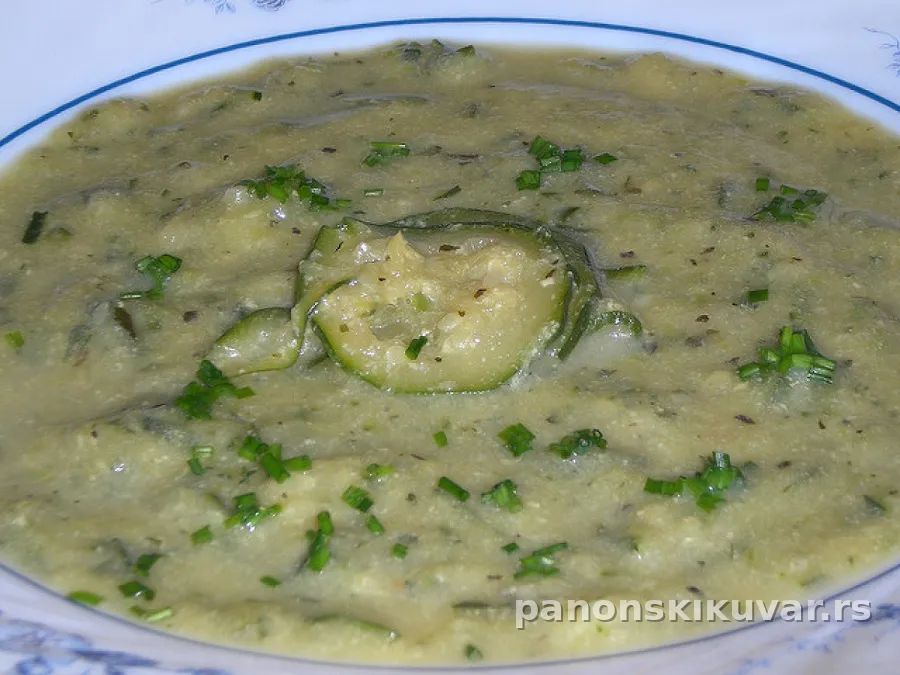 zlatno-zelena kremasta čorba od tikvica i krompira sa kačkavaljem, u beloj činiji posuta biberom