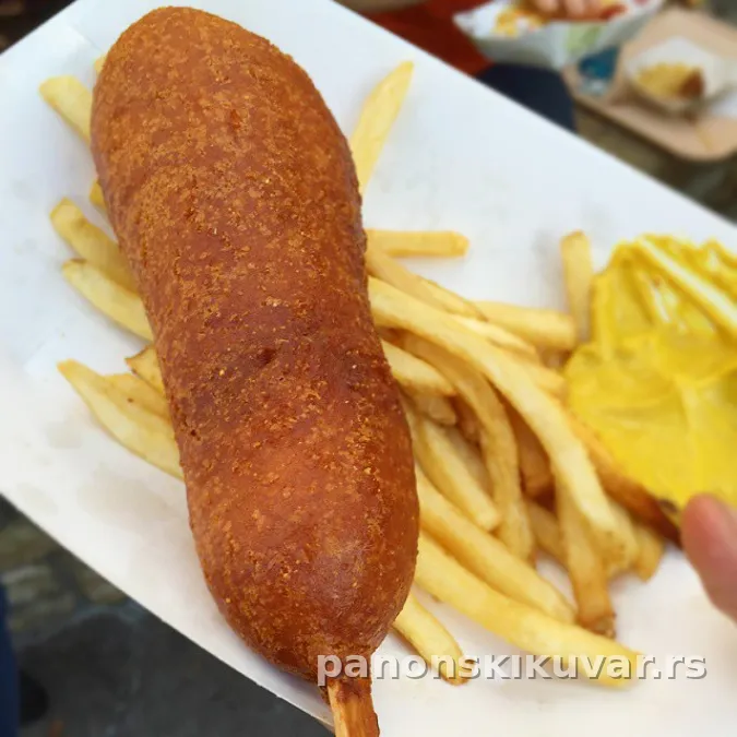 hrskavi zlatni corn dogovi na salvete, prelivi kečap i senf sa strane