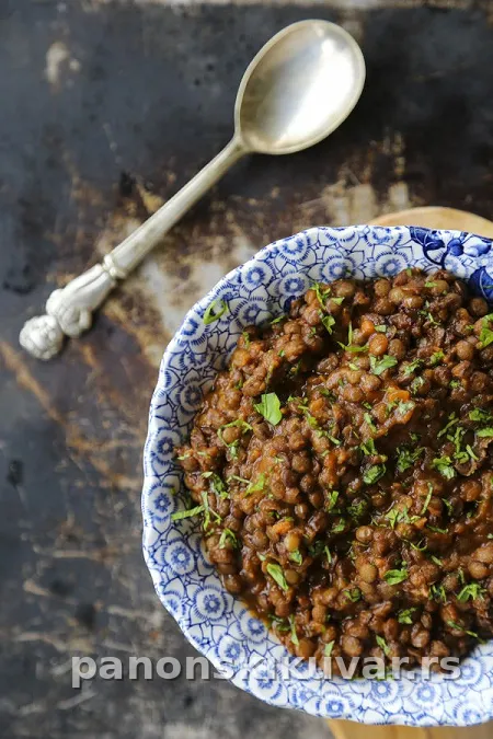 zgotovljeno varivo od sočiva sa zaprškom i seckanim belim lukom, servirano u činiji