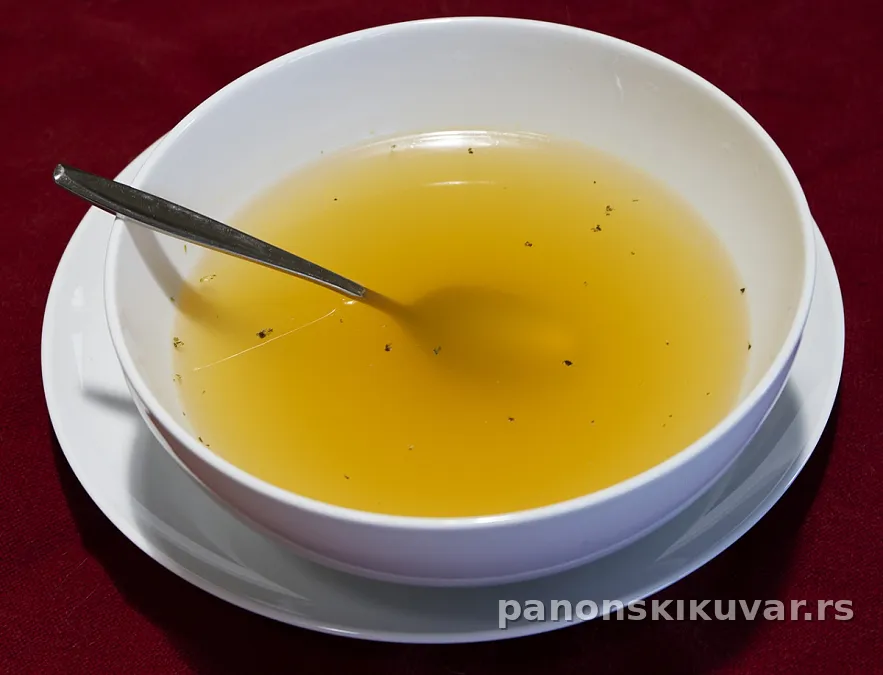 bistar hladan goveđi bujon u beloj šolji sa malo peršuna