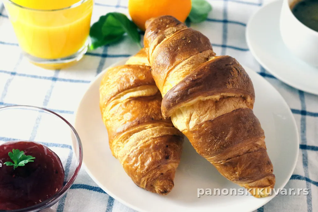 zlatno-smeđe kifle sa pekmezom na plehu, posute lagano brašnom i šećerom u prahu