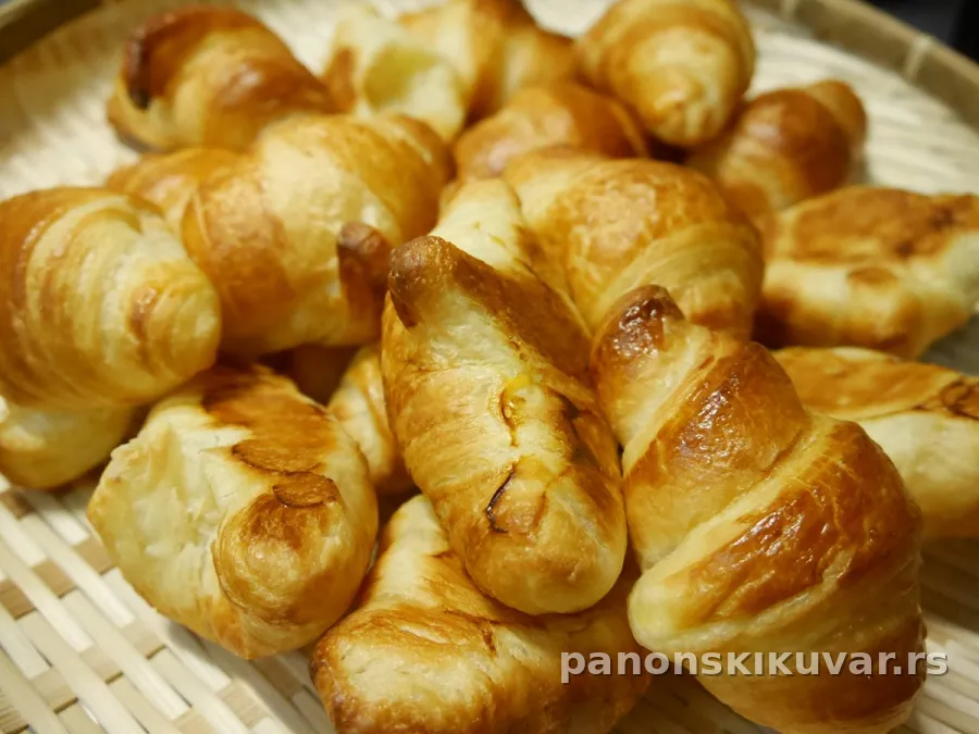 zlatno pečene kifle sa sirom na plehu, malo maslaca na vrhu