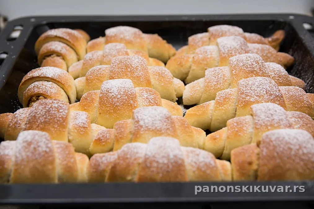 zlatno pečene kiflice sa pekmezom uvaljane u prah šećer na tanjiru