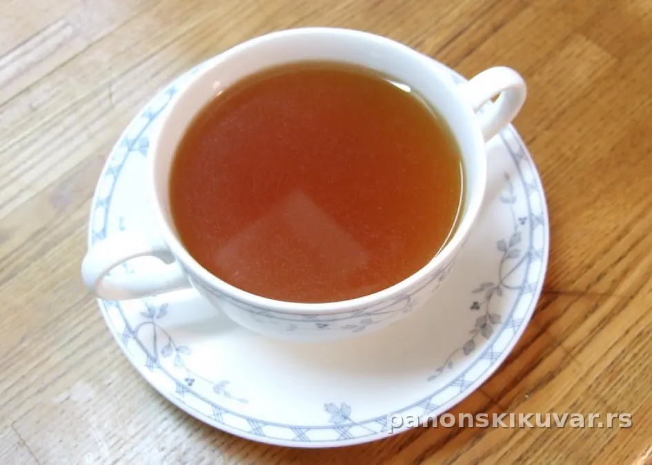 Topao bistro goveđi konsome, svetla prozirna supa u beloj šolji