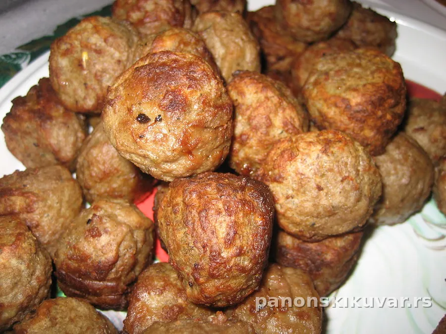 zlatno pržene mesne kuglice punjene zelenim maslinama, servirane uz sos