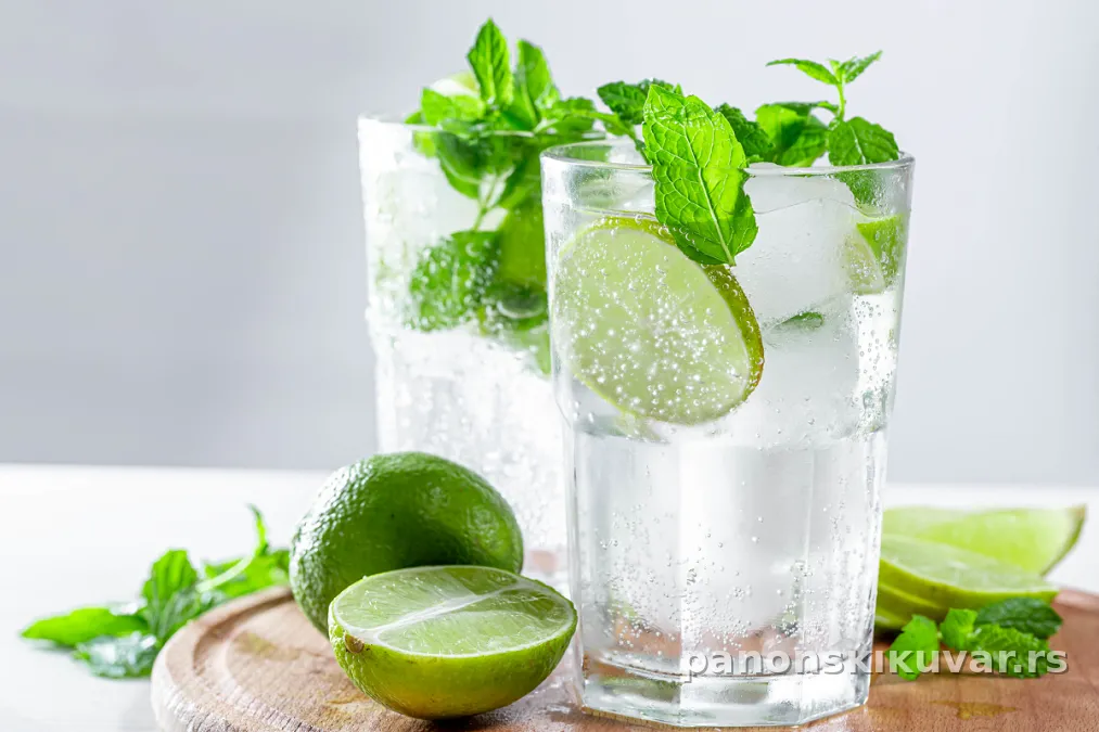 visoka čaša mojita sa izmrvljenim ledom, listovima nane i kriškom limete