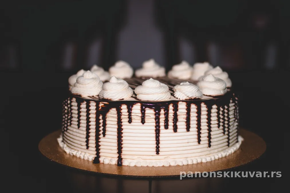 Monte torta sa dva sloja krema, posuta seckanim lešnicima i čokoladnim prelivom
