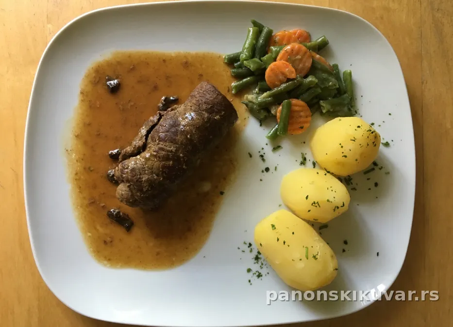 Zlatno prženi nadeveni teleći odrezak, isečen, poslužen sa krompirom i šargarepom