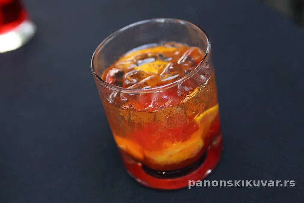 Old Fashioned u niskoj čaši sa ledom, višnjom i kolutom pomorandže