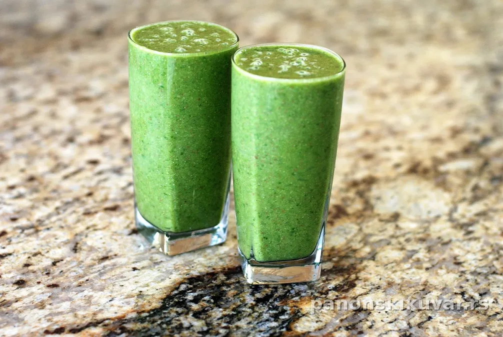 Čaša zelenog smoothija sa spanaćem, bananom, mangom i komadićima ananasa