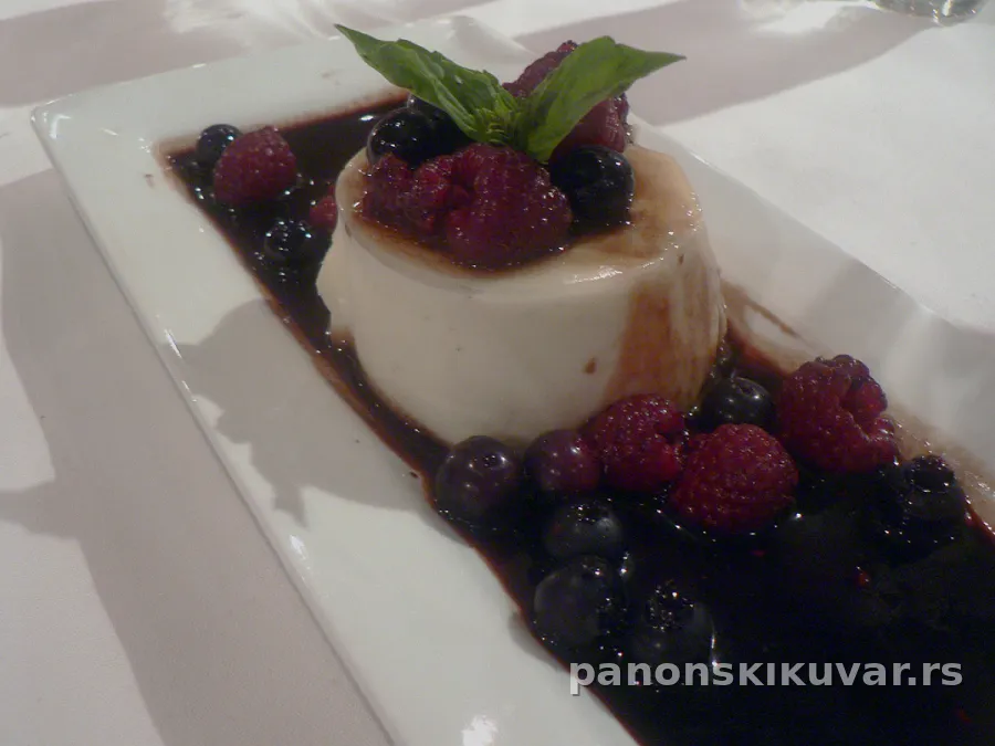 kremasta panna cotta u posudicama prelivena šarenim bobičastim voćem i listićima nane