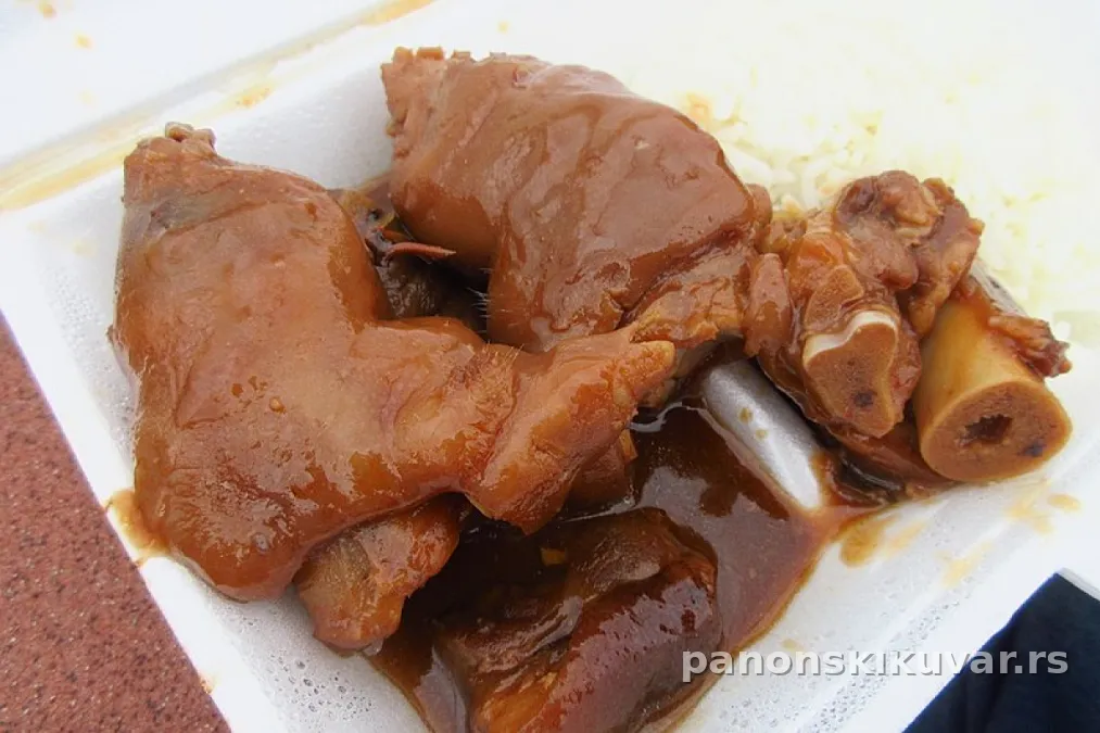 Porcija papaka u tamnom luku safta, posluženo uz kiseli kupus