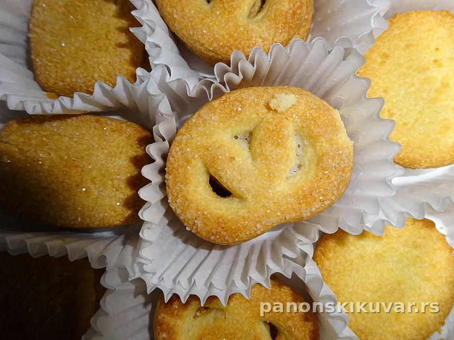 pečeni pašićevi pereci presečeni, premazani kajsijinim pekmezom i posuti sitnim bademom