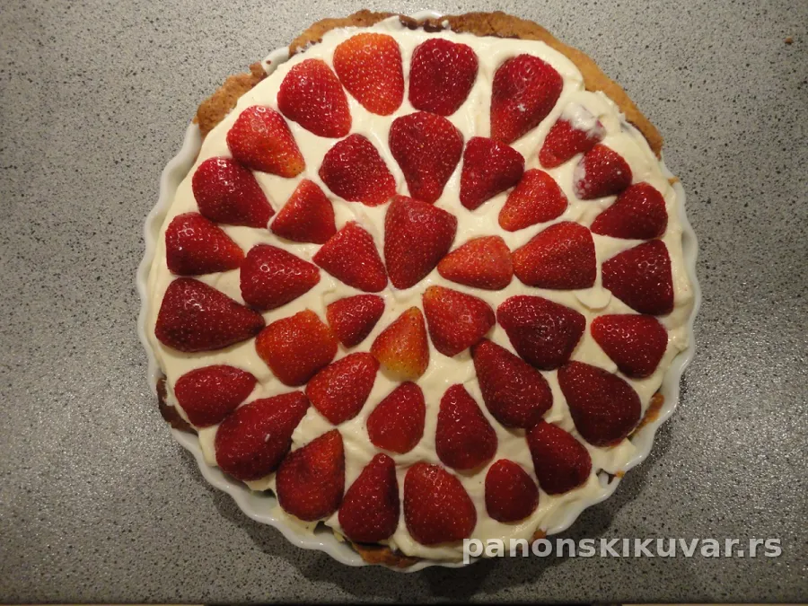 pita sa zlatnom korom, kremom i slojem svežih jagoda, presečena