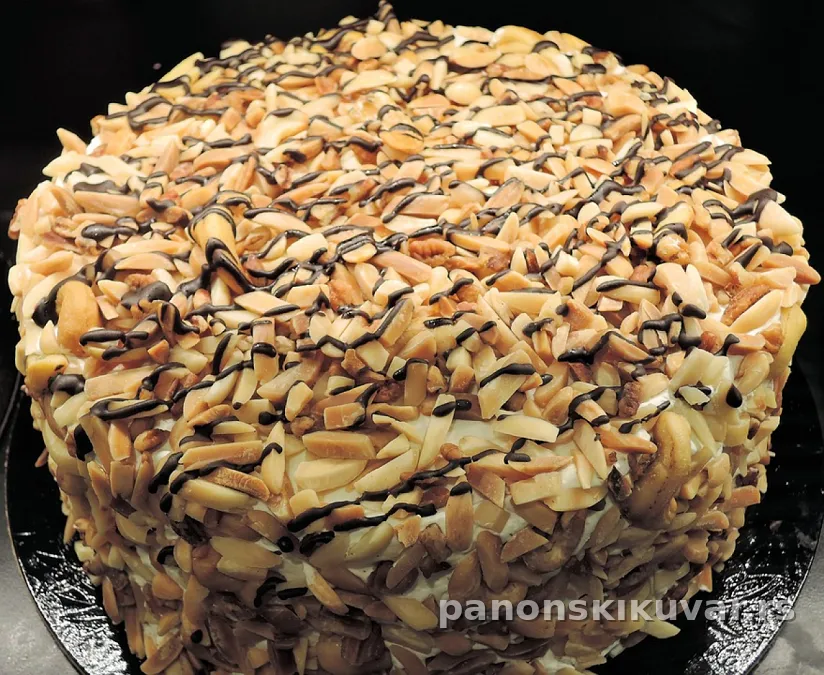 presecena provincijska torta sa belim punjenjem posuta seckanim bademima i glatkim kremom
