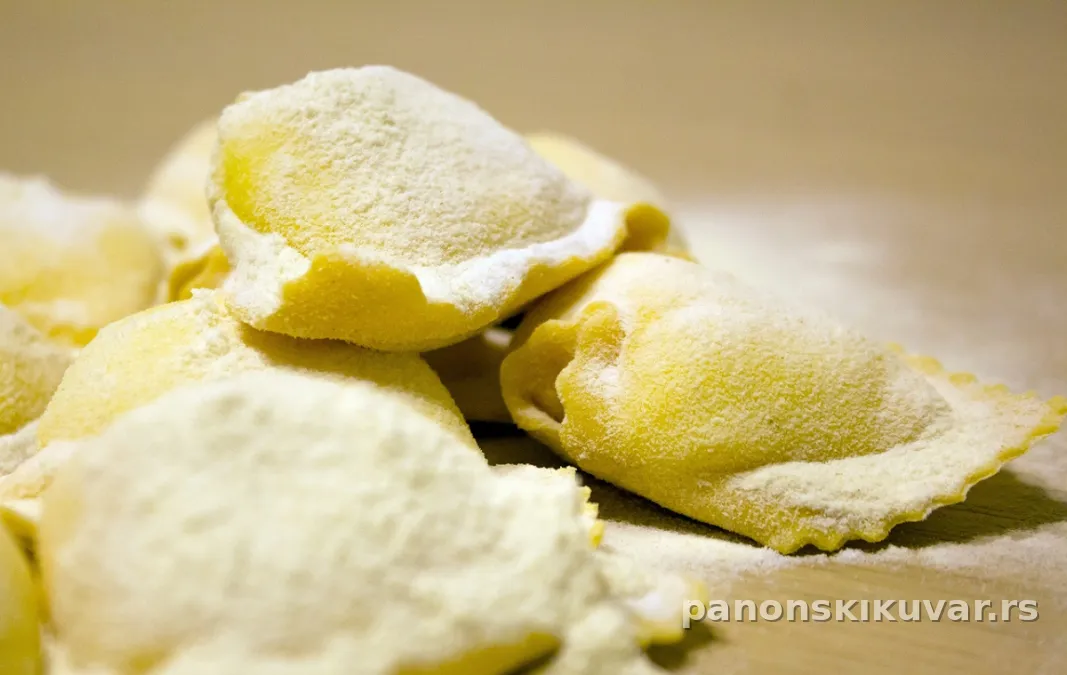 ravioli sa tečnim žumancetom preliveni zlatnim maslacem i ruzmarinom, posuto parmezanom