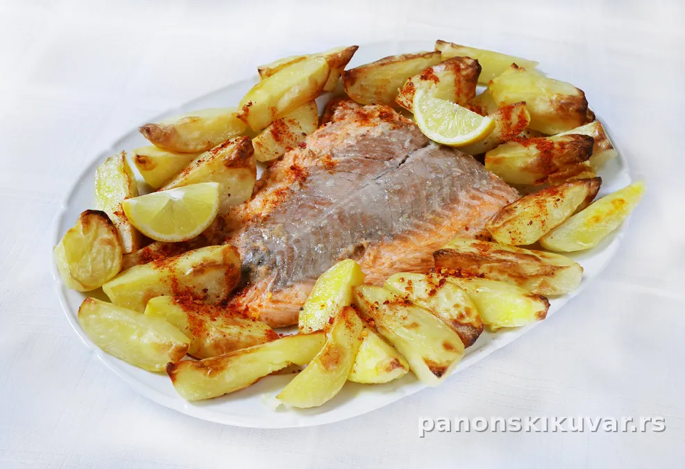 pečena riba u vinu sa krompirom i seckanim peršunom na tanjiru