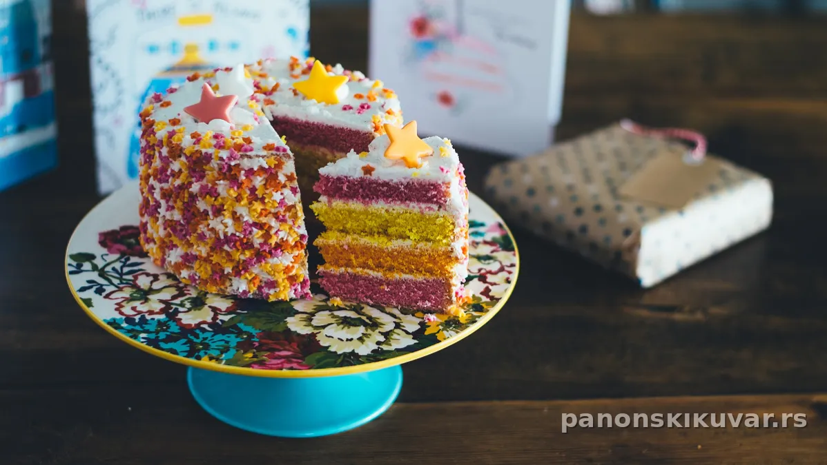 Višeslojna šarena torta sa pastelnim dezenima i belim puter filom