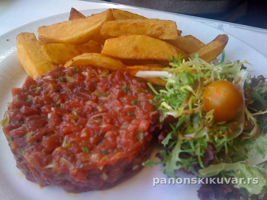 hlađeni tartar biftek sa žumancima i začinskim biljem na tanjiru