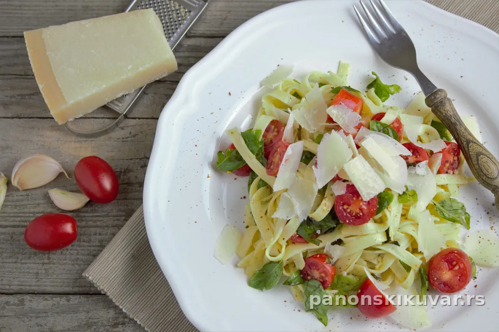 porcija testenine sa čeri paradajzom, bosiljkom i narendanim parmezanom, posuto maslinovim uljem