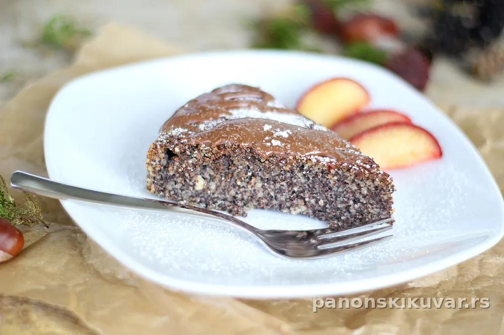 Presek torte od maka prekriven topljenom čokoladom, zlatnosmeđa kora, sočna sredina